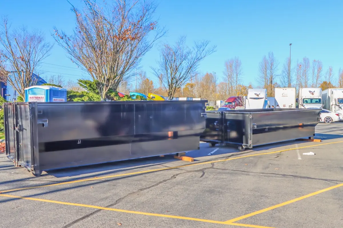 Professional dumpster rental service with roll-off container on residential driveway in Omak